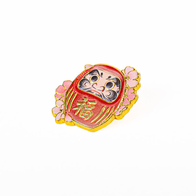 Insignia japonesa de metal con motivos de Daruma y Sakura